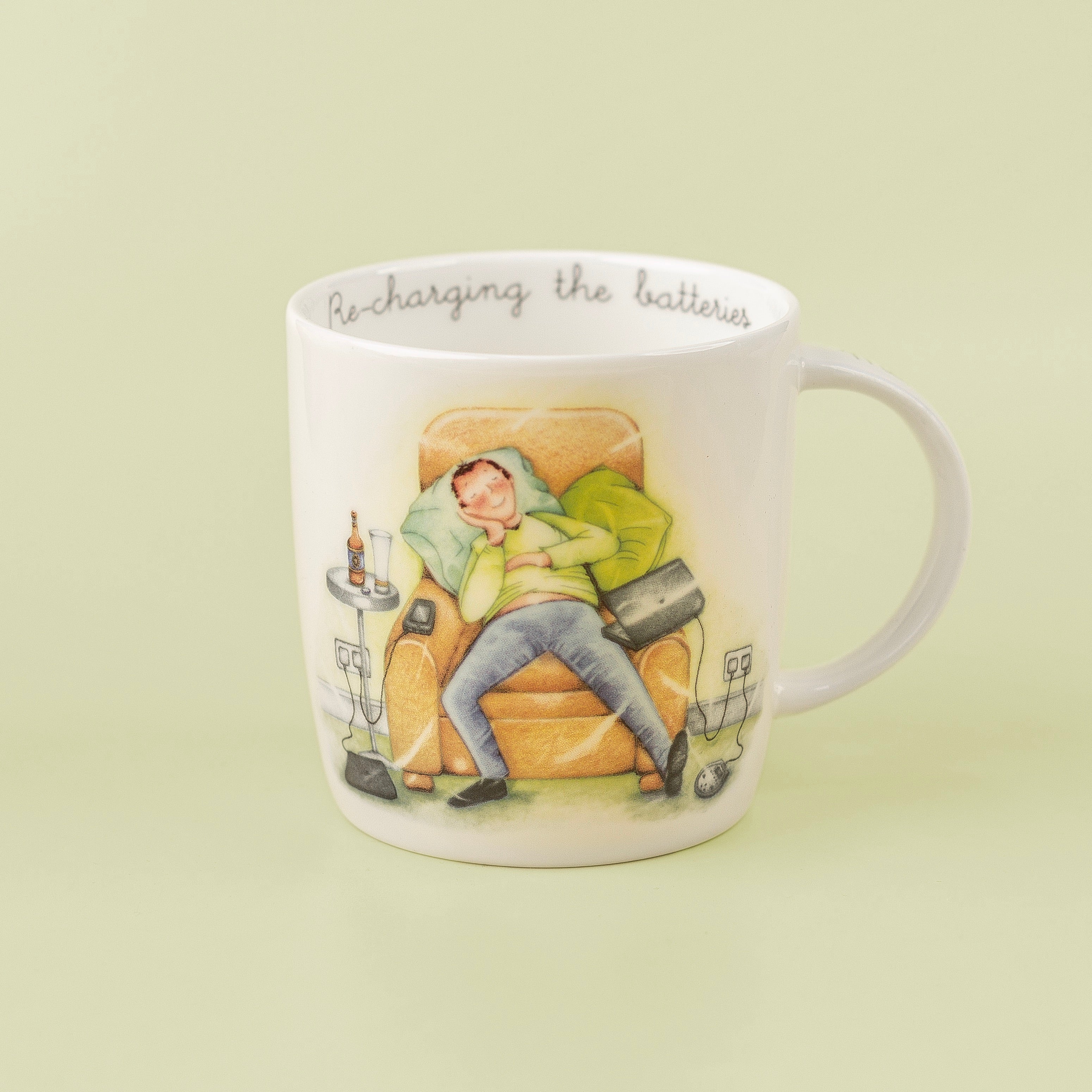 A white fine china mug with an illustration of a man sleeping in a chair and the text 'Re-charging the batteries' on the side.