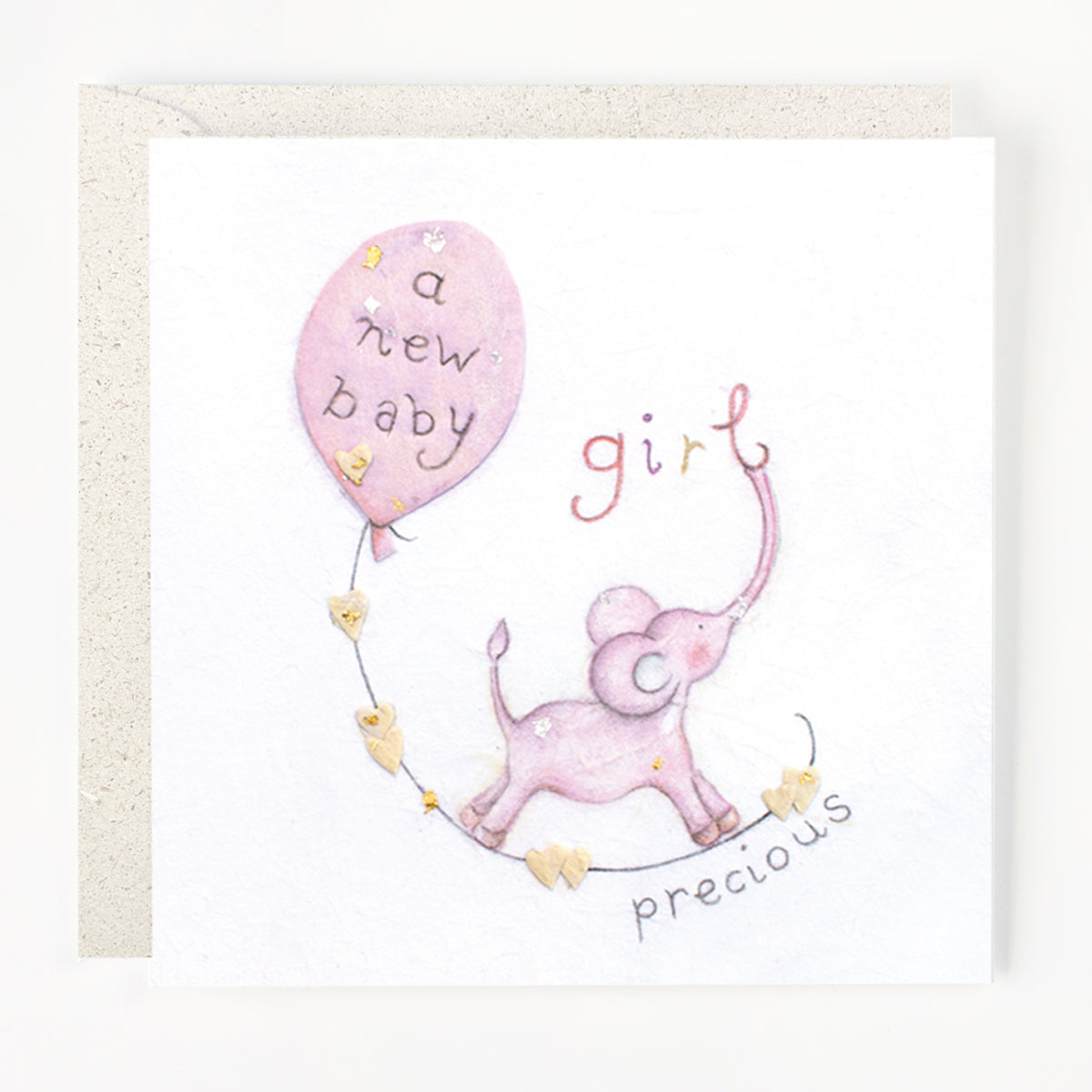 A greeting card with an illustration of an elephant holding a balloon with the text 'a new baby girl' and another text 'precious' on it.