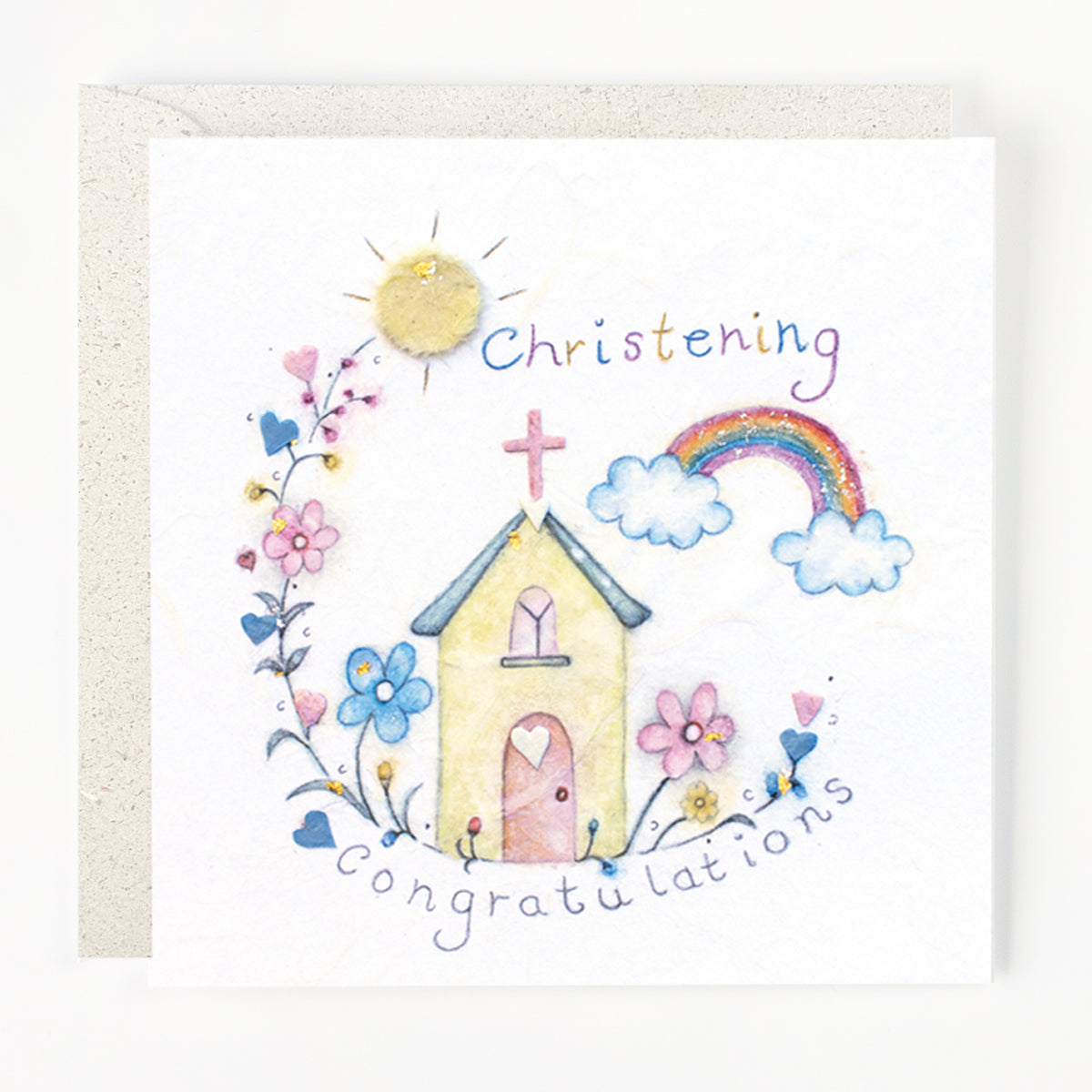 A greeting card with a hand drawn illustration of a church, rainbow, sun, and flowers, with the text 'Christening Congratulations' written on it.