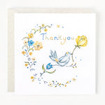 A greeting card with a floral design and the text 'Thank you' printed on it, accompanied by a floral pattern and a bird illustration.