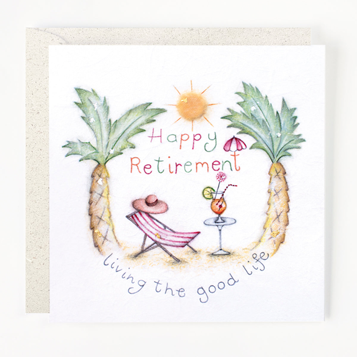 A greeting card with an illustration of pineapples, a deck chair, sunglasses, a cocktail, and the text 'Happy Retirement' and 'Living the good life'.