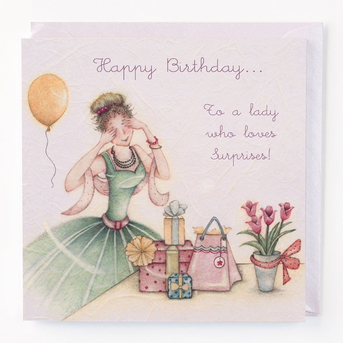 A birthday card with an illustration of a woman in a green dress surrounded by gift boxes, a balloon, and flowers. The card has 'Happy Birthday.